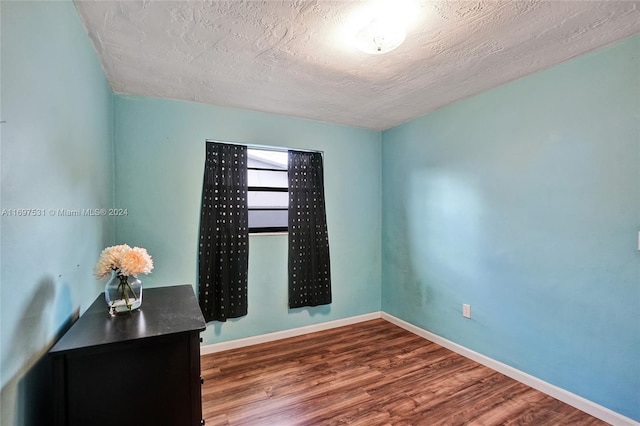 empty room featuring hardwood / wood-style floors and a textured ceiling