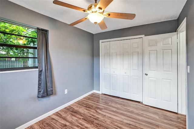 unfurnished bedroom featuring ceiling fan, a closet, and light wood-type flooring