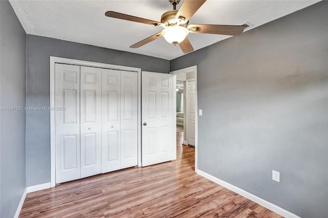 unfurnished bedroom with ceiling fan, a closet, and light hardwood / wood-style floors