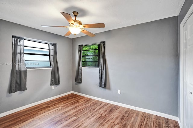 spare room featuring hardwood / wood-style flooring, ceiling fan, and a healthy amount of sunlight