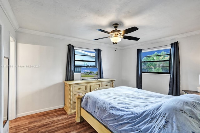 bedroom featuring crown molding, ceiling fan, and dark wood-type flooring