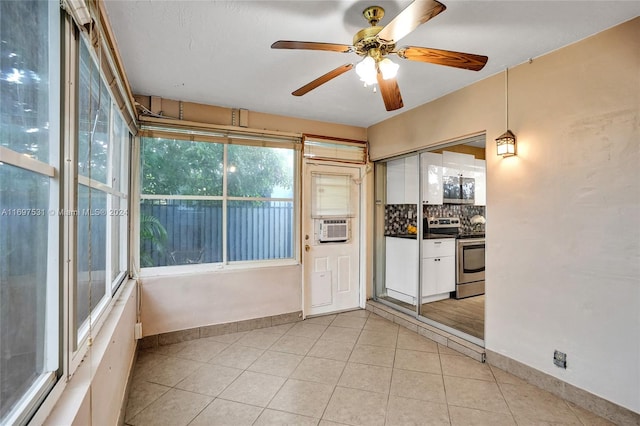 unfurnished sunroom with ceiling fan and cooling unit