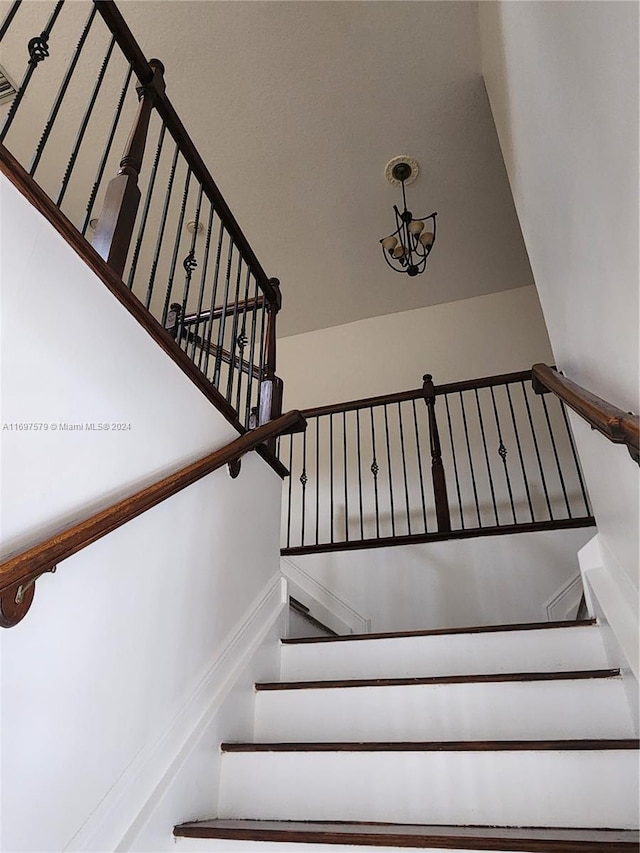 stairway with a chandelier