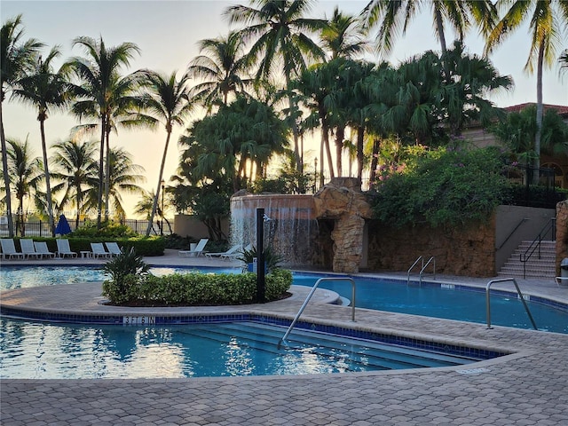 pool at dusk featuring a patio