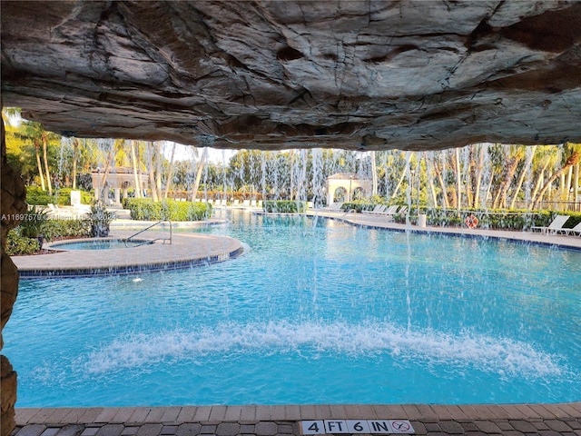 view of swimming pool with an in ground hot tub