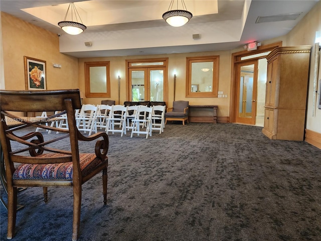 sitting room featuring a raised ceiling, french doors, and carpet floors