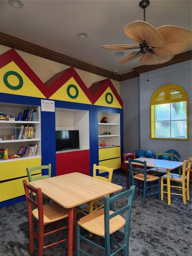 rec room featuring carpet floors, built in features, ceiling fan, and crown molding