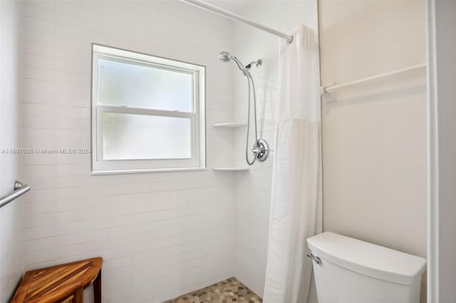 bathroom with curtained shower and toilet