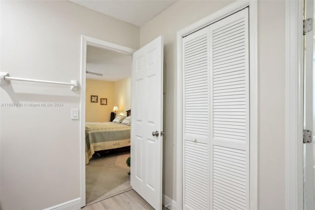 bedroom featuring light hardwood / wood-style floors, a textured ceiling, and a closet