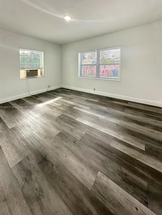 unfurnished room featuring dark hardwood / wood-style floors, plenty of natural light, and cooling unit