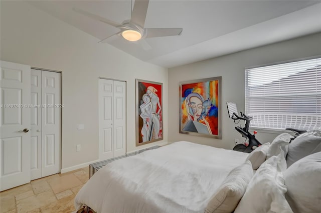 bedroom with two closets, vaulted ceiling, and ceiling fan