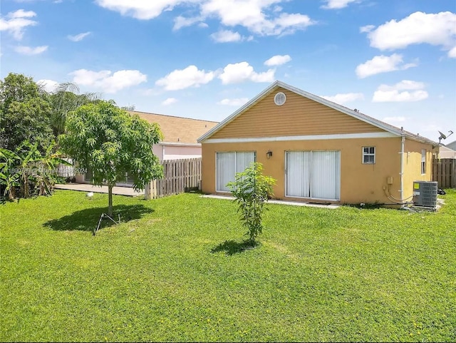 back of property with a lawn and central air condition unit