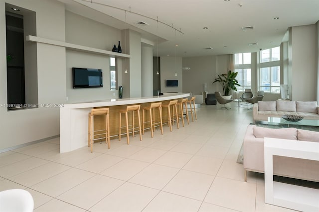 kitchen with a kitchen bar and light tile patterned floors