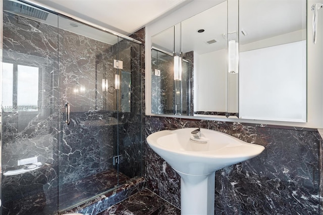 bathroom featuring tile walls and a shower with shower door