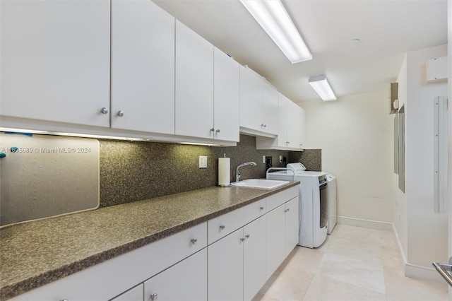 washroom featuring washer and clothes dryer, light tile patterned floors, cabinets, and sink