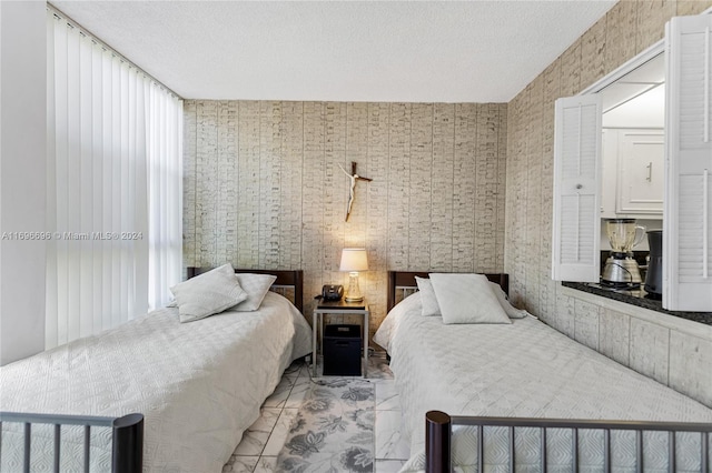 bedroom with a textured ceiling and light tile patterned flooring