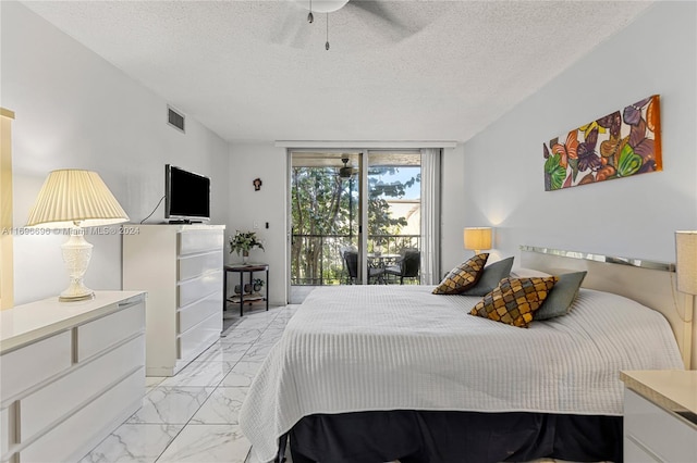 bedroom featuring access to outside, ceiling fan, and a textured ceiling