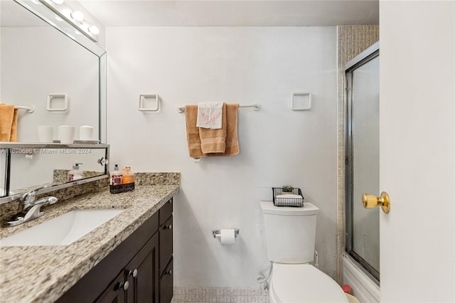 full bathroom featuring vanity, toilet, and enclosed tub / shower combo