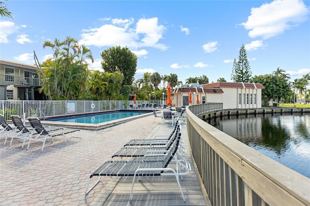 view of pool featuring a water view and a patio area