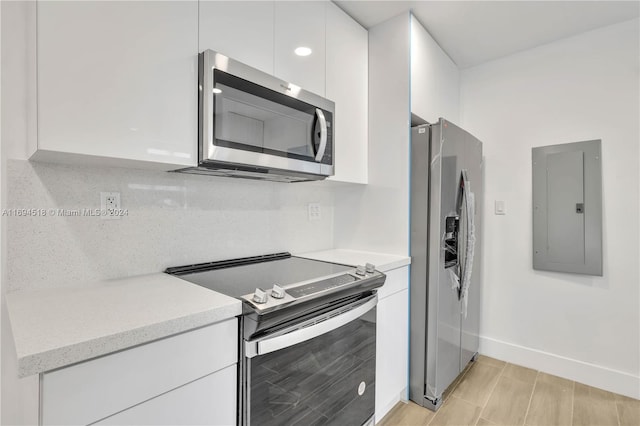 kitchen with backsplash, white cabinetry, stainless steel appliances, and electric panel