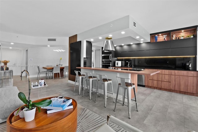 kitchen featuring backsplash, a center island, a kitchen bar, and stainless steel appliances