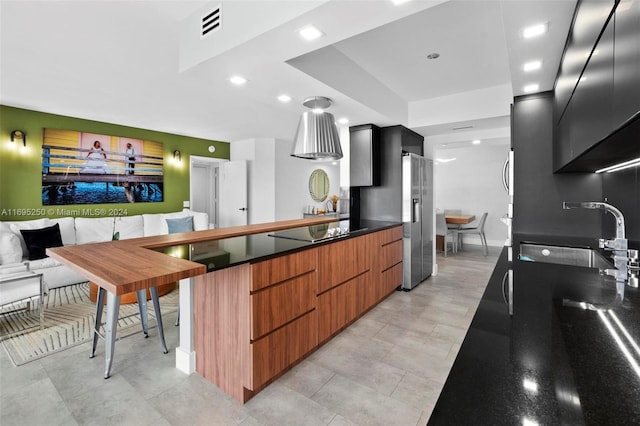 kitchen with stainless steel fridge, black electric cooktop, and sink