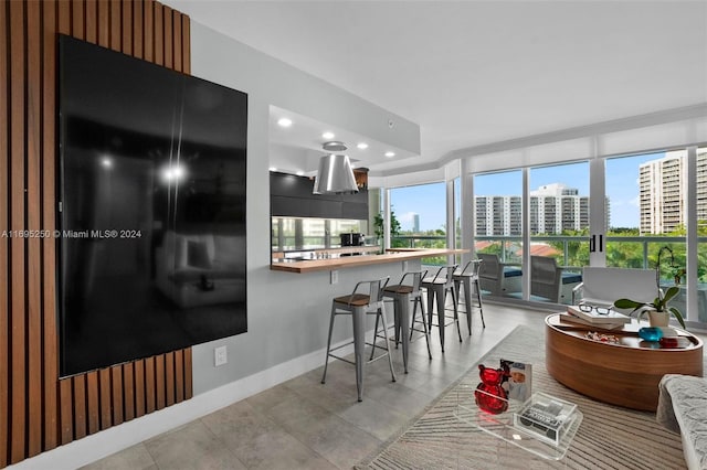 kitchen with kitchen peninsula, a kitchen breakfast bar, and light tile patterned floors