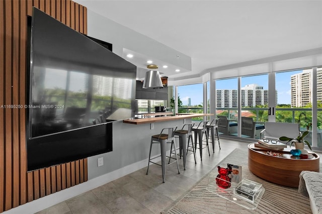 kitchen featuring a kitchen breakfast bar, plenty of natural light, and light tile patterned flooring