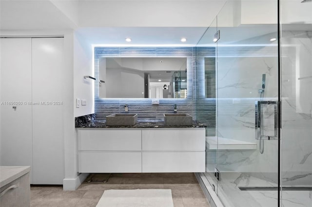 bathroom with decorative backsplash, vanity, and an enclosed shower