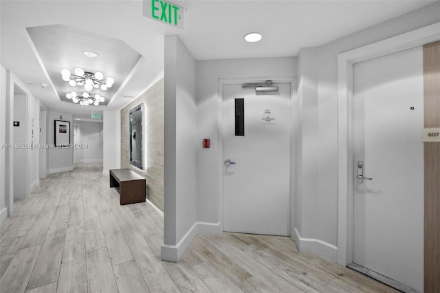 corridor with an inviting chandelier and light wood-type flooring