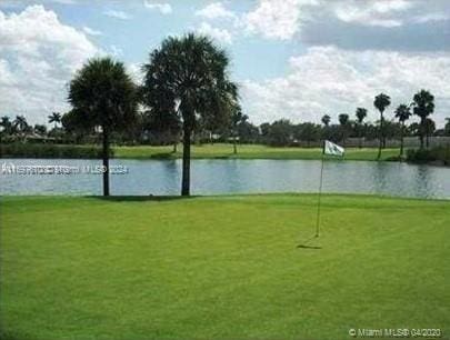 view of community with a water view and a lawn