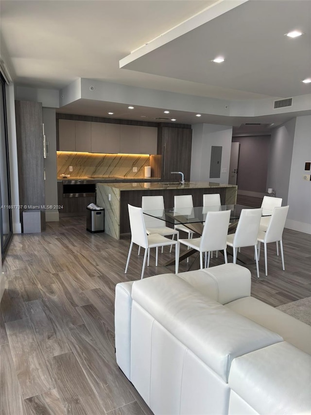 living room featuring hardwood / wood-style floors, electric panel, and sink