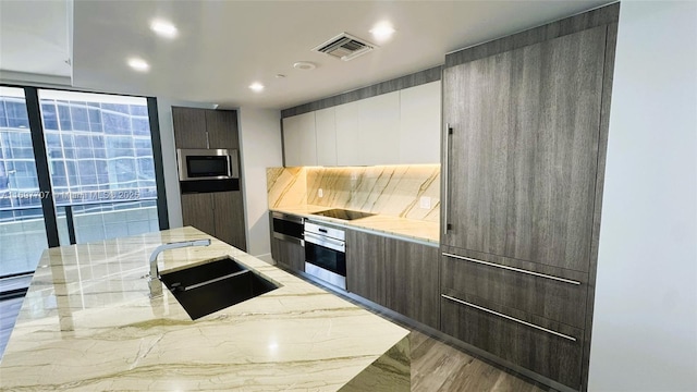 801 S Miami Ave Unit 3205/04, Miami, FL 33130 - kitchen with a sink, light stone counters, visible vents, modern cabinets, and appliances with stainless steel finishes