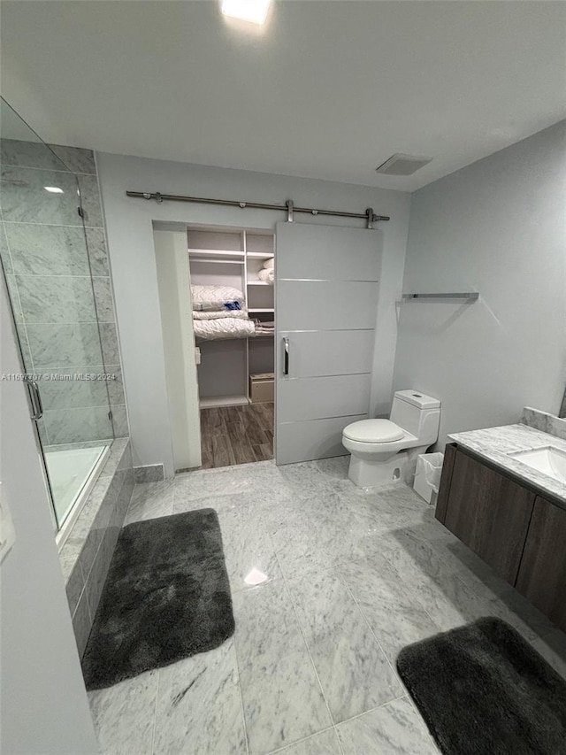 full bathroom featuring shower / bath combination with glass door, vanity, toilet, and a wealth of natural light