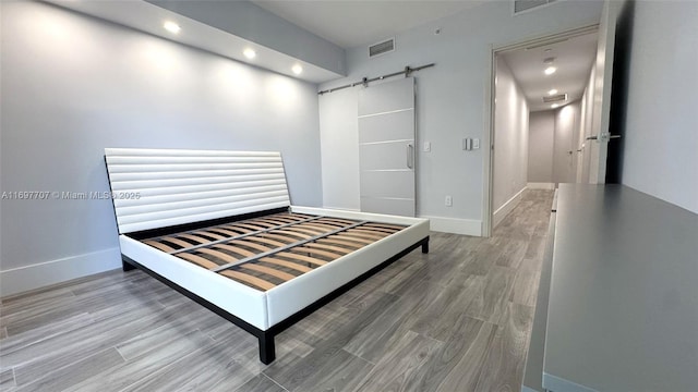 801 S Miami Ave Unit 3205/04, Miami, FL 33130 - bedroom featuring visible vents, baseboards, wood finished floors, recessed lighting, and a barn door