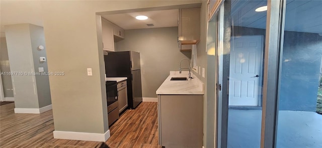 kitchen featuring sink, electric range oven, dark hardwood / wood-style floors, and stainless steel fridge