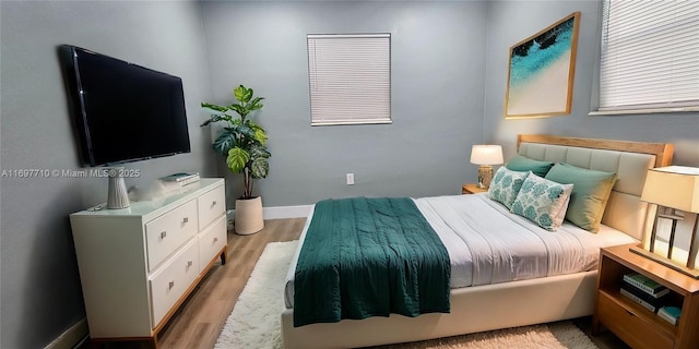 bedroom with light wood-style floors and baseboards