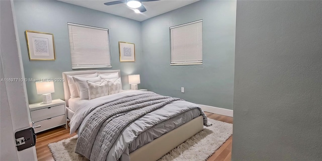 bedroom with ceiling fan, light wood-type flooring, and baseboards