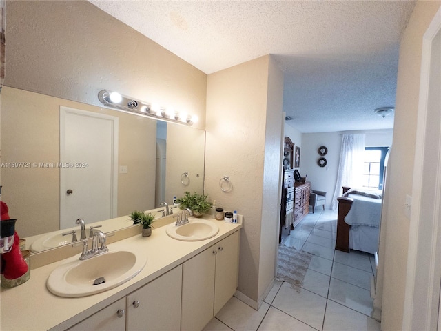 bathroom with tile patterned floors, vanity, and a textured ceiling