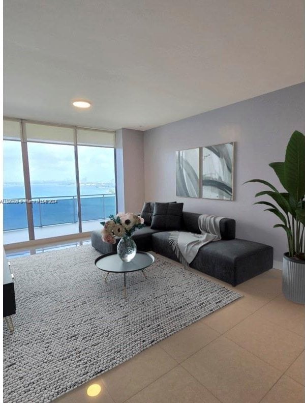 tiled living room with floor to ceiling windows and a water view