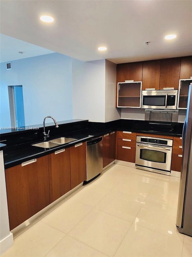 kitchen featuring sink, light tile patterned floors, and stainless steel appliances