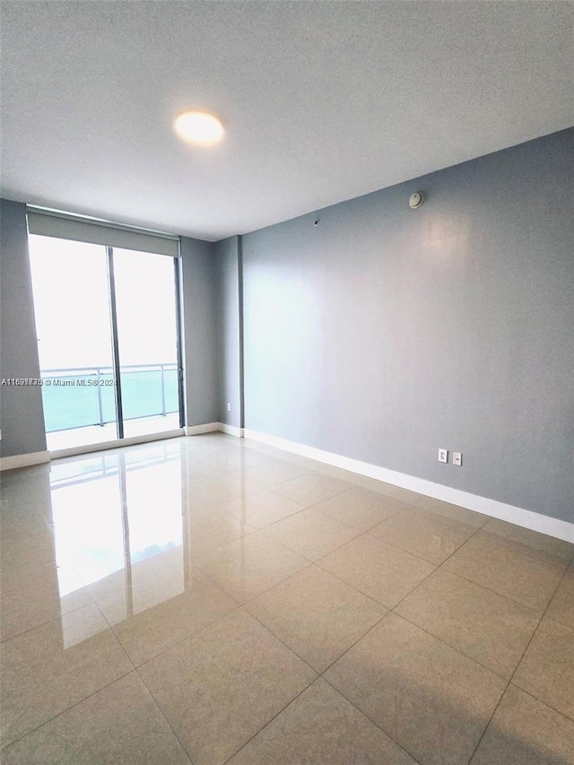 spare room featuring a water view and a textured ceiling