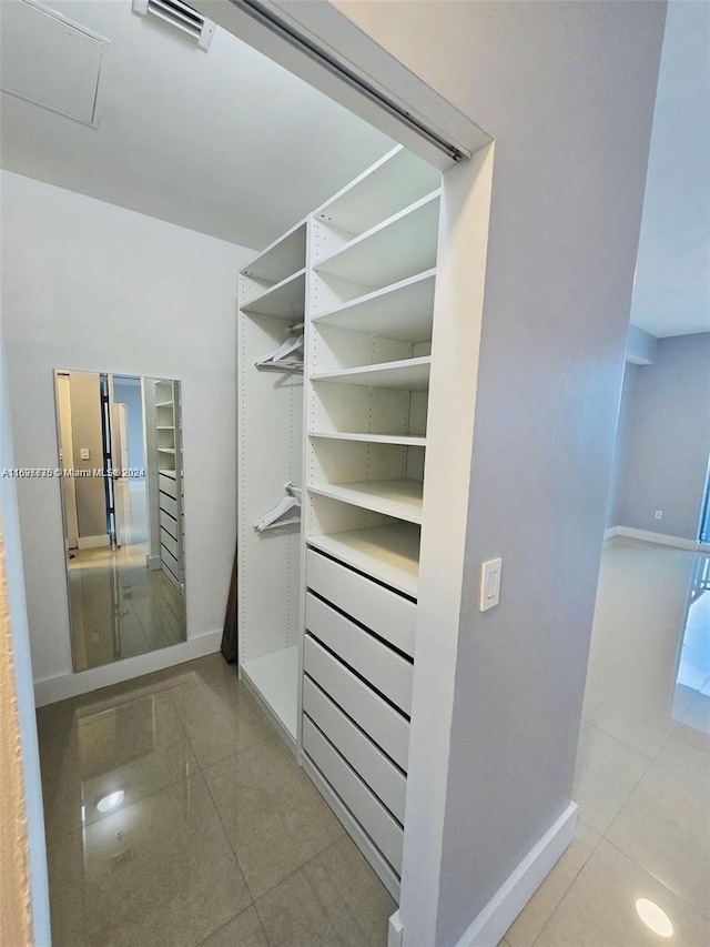 walk in closet with light tile patterned floors