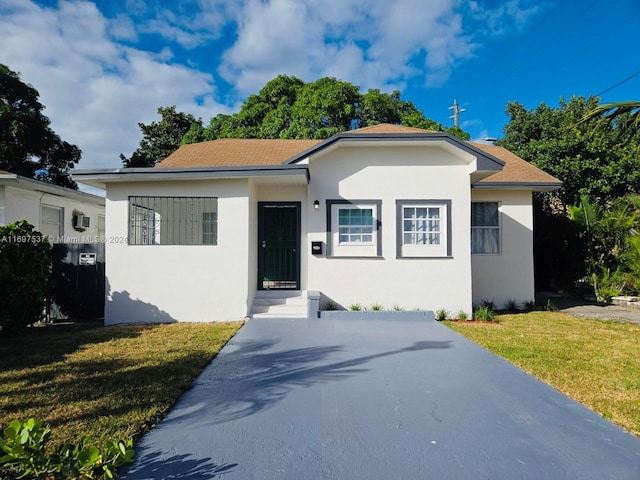 bungalow featuring a front lawn