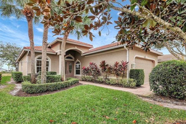 mediterranean / spanish-style house featuring a garage and a front lawn