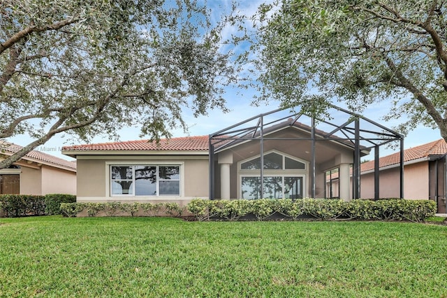 back of property featuring a lanai and a yard