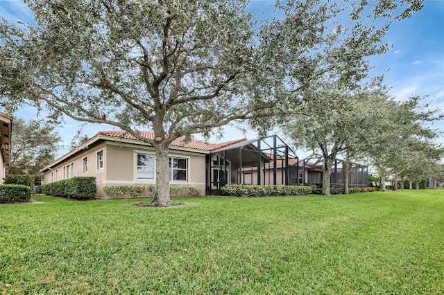 exterior space with glass enclosure and a lawn