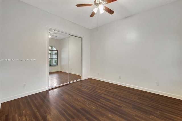 unfurnished bedroom featuring ceiling fan, dark wood-type flooring, and a closet