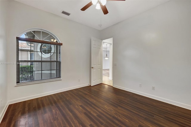 spare room with ceiling fan and dark wood-type flooring