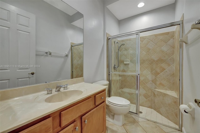 bathroom with toilet, vanity, tile patterned floors, and a shower with shower door